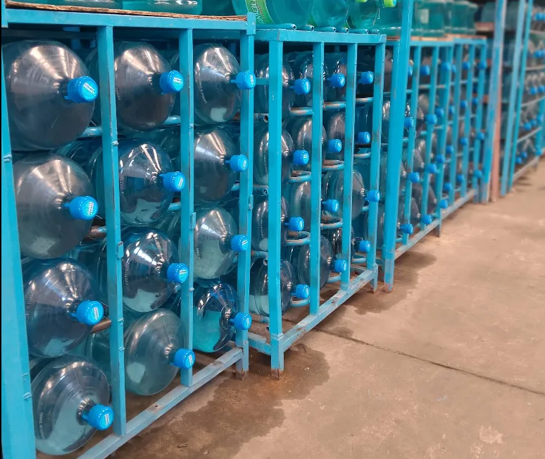 Bidones de agua Echanique con tapa celeste apilados en estanterías de reparto