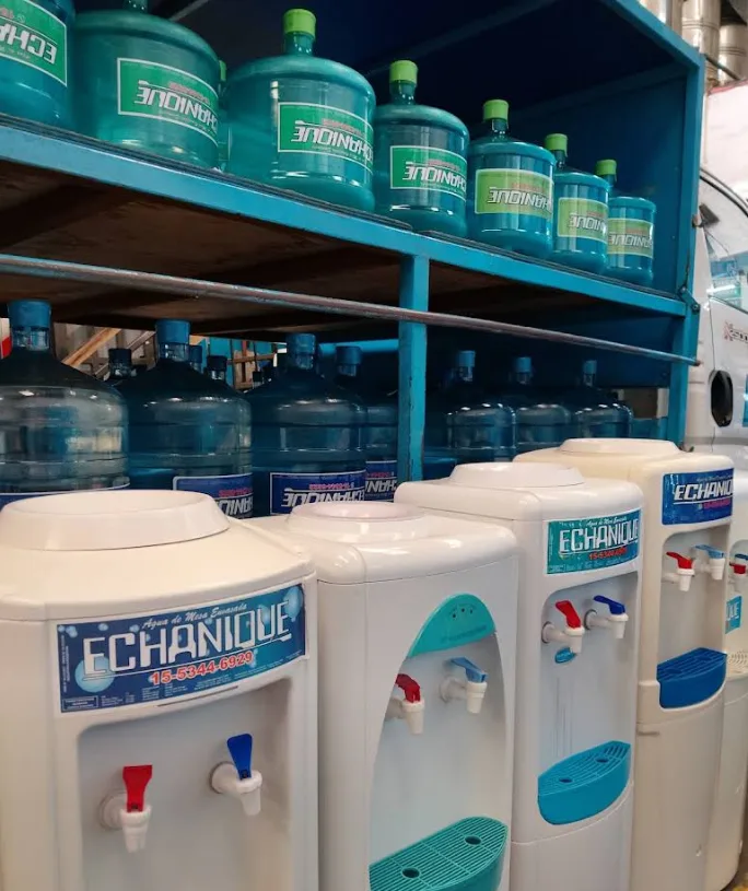 Dispensers de agua blancos con canillas fría y natural y logo Echanique, junto a bidones