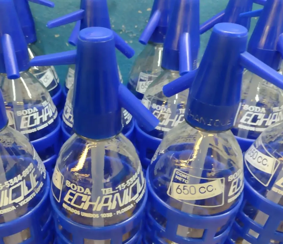 Sifones de soda Echanique de 650 cc con cabezal azul en cajones de reparto